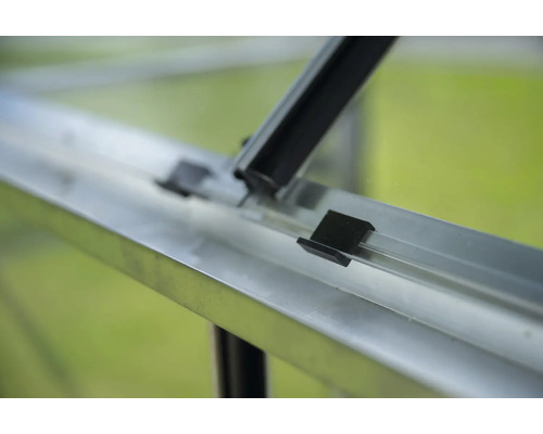 Detailansicht eines Gewächshauses mit Aluminiumrahmen und schwarzen Befestigungselementen