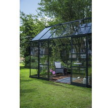 Gewächshaus mit Pflanzen, Stuhl und Gartenzubehör im Garten