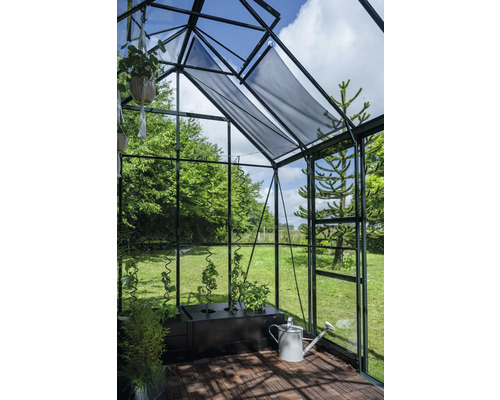 Gewächshaus mit Pflanzen, Bewässerungskanne und Sonnenschutz