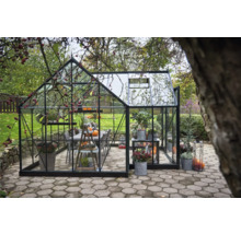 Gewächshaus mit Pflanzen und Tischgruppe im Garten