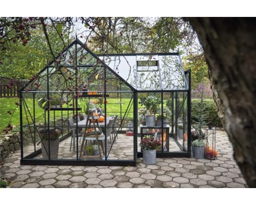 Gewächshaus mit Pflanzen und Tischgruppe im Garten