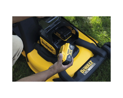 Eine Person setzt einen 18-Volt-Akku in einen gelben Rasenmäher von DeWalt ein.