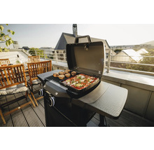 Gasgrill mit Speisen auf einem Balkon mit Sitzbereich