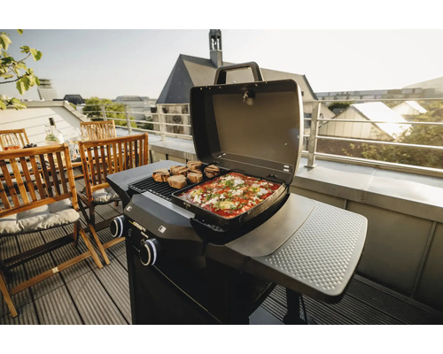 Gasgrill mit Speisen auf einem Balkon mit Sitzbereich