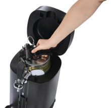 Bierzapfanlage mit eingesetztem Fass und einer Hand, die einen Zapfhahn bedient.