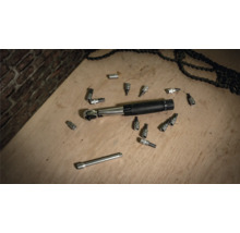 Drehmomentschlüssel mit Steckschlüsseln und Ketten auf einer Holzoberfläche