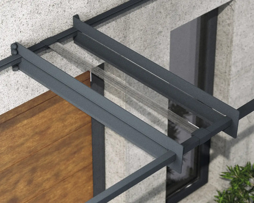 Detailansicht eines Vordachs mit anthrazitfarbenem Aluminiumrahmen und transparenter Glasabdeckung an einer Fassade.