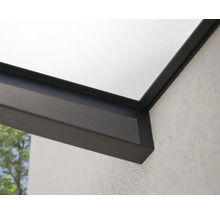 Detailansicht einer Terrassenüberdachung mit Aluminiumprofilen und einer Glasplatte an einer strukturierten Hauswand.