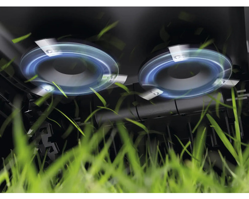 Nahaufnahme des Mähwerks eines Rasenmähers beim Schneiden von Gras