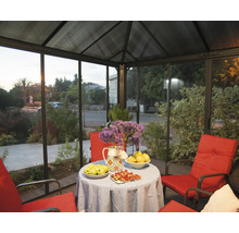 Überdachter Sitzbereich mit Tisch, Blumen und rotem Mobiliar