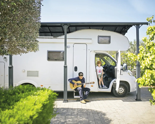 Wohnmobil unter einem Carport mit spielenden Kindern