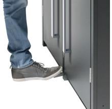 Person öffnet Möbeltür mit Fußbedienung