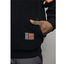 Detailaufnahme einer schwarzen Fleecejacke mit Hornbach DIY Nation-Logo und Hand in der Tasche