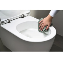 Eine Person reinigt eine weiße Hänge-Toilette mit einem Tuch.