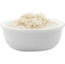 Weißes Keramikgefäß gefüllt mit Fischpüree