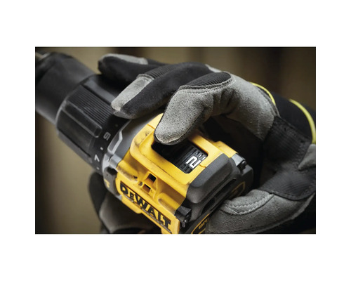 Nahaufnahme einer Person mit Handschuhen, die einen gelben DeWalt Akku-Bohrschrauber hält.