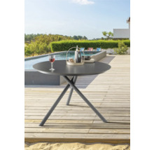 Runder Gartentisch auf einer Terrasse mit Pool und Garten im Hintergrund.