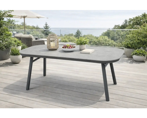 Grauer Gartentisch auf einer Terrasse mit Meerblick.