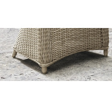 Detailansicht eines geflochtenen Gartenmöbels mit Füßen.