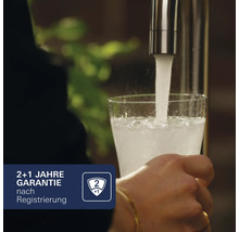 "Ein Glas wird mit Wasser aus einem Wasserhahn gefüllt