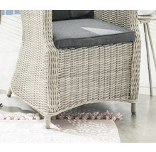 Detailansicht eines Rattansessels mit grauen Sitzkissen