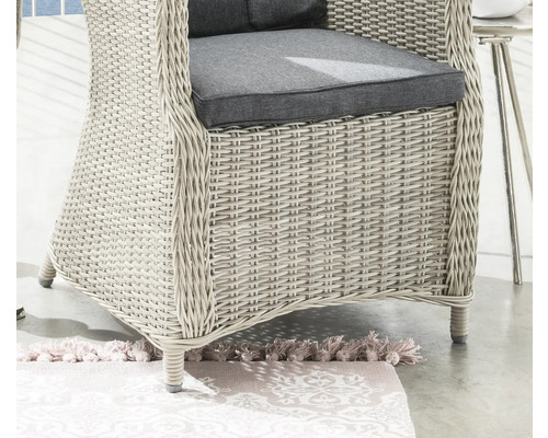 Detailansicht eines Rattansessels mit grauen Sitzkissen