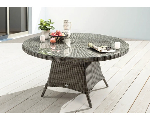 Runder Gartentisch aus Rattan mit Glasplatte auf einer Terrasse