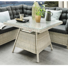 Gartentisch mit Glasplatte und Rattanstruktur, Teil einer Sitzgruppe für den Außenbereich