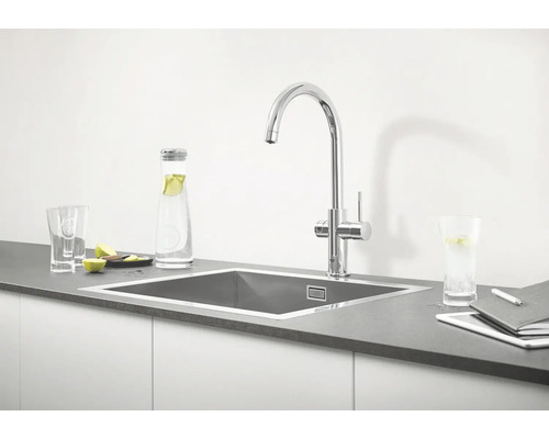 Küchenspüle mit Wasserhahn, Wasserflasche, Gläsern und Tablet