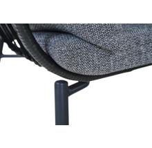 Nahaufnahme eines Gartenmöbels mit grauem Polsterkissen, schwarzem Polyrattan-Geflecht und einem Metallbein.