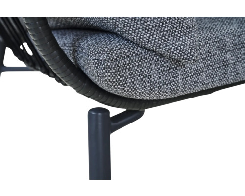 Nahaufnahme eines Gartenmöbels mit grauem Polsterkissen, schwarzem Polyrattan-Geflecht und einem Metallbein.