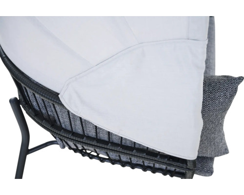 Detail eines Gartenstuhls mit dunklem Metallrahmen, Polster und weißem Textilbezug.