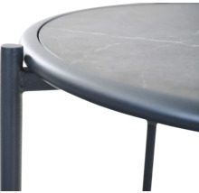 Detailansicht eines runden Beistelltisches mit Tischplatte in Steinoptik und dunklem Metallgestell.