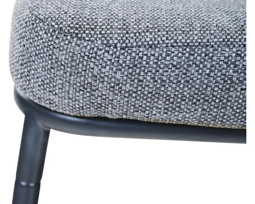 Nahaufnahme einer Sitzfläche mit strukturiertem Webstoff und schwarzem Metallgestell.