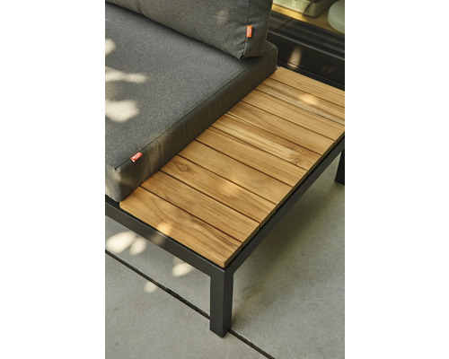 Gartenlounge mit schwarzem Metallrahmen, grauen Sitzkissen und integrierter Ablage aus Holzlatten.