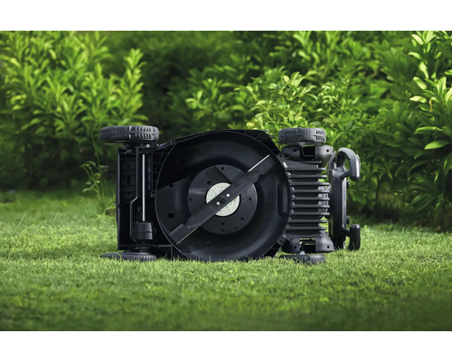 Ein Rasenmäher liegt auf dem Rasen und zeigt das Messer.