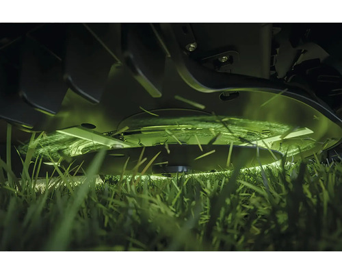 Detailaufnahme eines Rasenmähers beim Schneiden von Gras