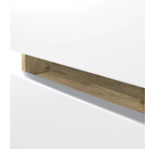 Detailansicht einer weißen Möbelfront mit einer Griffmulde in Holzoptik.