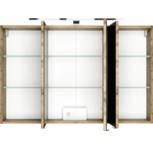 Geöffneter dreitüriger Spiegelschrank in Holzoptik mit Glaseinlegeböden, integrierter Steckdose und LED-Aufsatzleuchte.