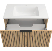 Waschtischunterschrank in Eichenoptik mit Lamellen-Front, weißes Waschbecken und geöffnete Schublade mit schwarzem Griff.
