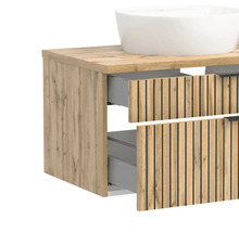 Waschbeckenunterschrank in Holzoptik mit Lamellen-Front, zwei Auszügen und weißem Aufsatzwaschbecken.