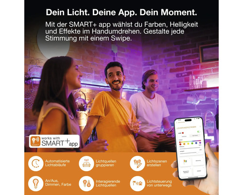 Drei Personen in einem Raum mit bunter Smart-Beleuchtung, gesteuert über eine App auf einem Smartphone für Farbe, Helligkeit und Zeitpläne.