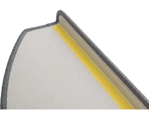 Detail einer Treppenstufe mit Textiloberfläche und Klebestreifen zur Befestigung.