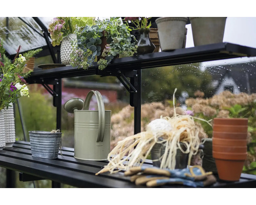 Gewächshausregal mit Gießkanne, Pflanzgefäßen und Gartenzubehör