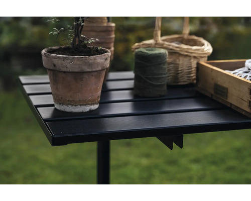 Gartentisch mit Blumentopf, Garnrolle und Holzkiste