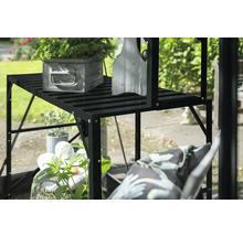 Schwarzes Pflanzregal mit Pflanzen und Dekoration im Garten