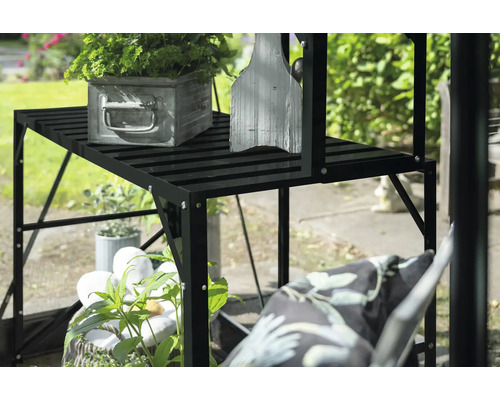 Schwarzes Pflanzregal mit Pflanzen und Dekoration im Garten