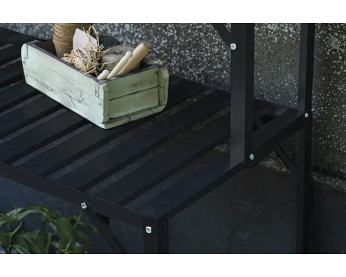 Detailansicht eines schwarzen Pflanzenregals mit einer dekorierten Holzkiste