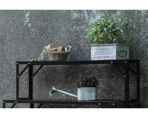 Schwarzes Metallregal mit Gartenutensilien wie Gießkanne, Pflanzen und Korb