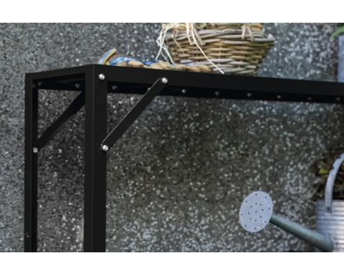 Detailansicht eines schwarzen Gartentisches mit Dekoration und Gießkanne